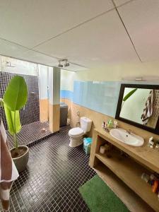 a bathroom with a sink and a toilet and a tv at The Little House in Hiriketiya