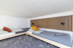 two beds in a room with wooden walls at SuperApart Orla 5 in Warsaw