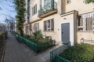 a white building with a door and a fence at SuperApart Orla 5 in Warsaw