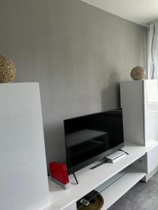 a living room with a flat screen tv on a white cabinet at Ferienwohnung Zur Wildkatze in Hallenberg