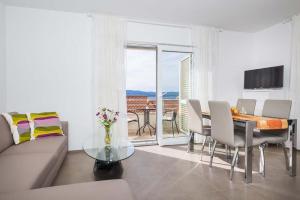 a living room with a couch and a table with chairs at Apartments Vista Bol in Bol