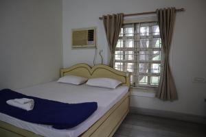 a bedroom with a large bed with a window at SWET APARAJITA in Bolpur
