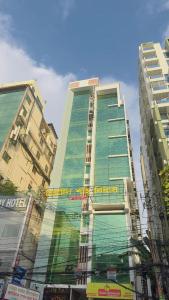 een hoog groen gebouw met een bord erop bij Hotel Shah Nibash Panthapath in Dhaka
