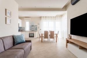 a living room with a couch and a table with chairs at La casa del sole a 50 m dal mare in Lido di Camaiore