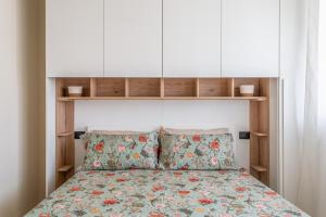 una camera da letto con un letto con copriletto floreale di La casa del sole a 50 m dal mare a Lido di Camaiore