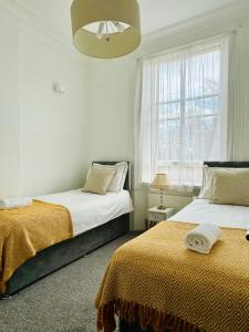 a bedroom with two beds and a window at Harrington Apartments in Central London in London