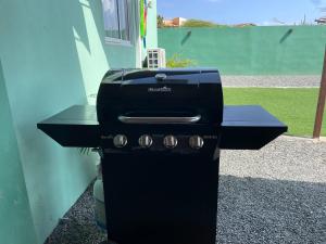 a black grill sitting outside of a house at Cozy apartment in Savaneta in Savaneta