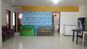 - un salon avec un canapé vert et un mur bleu dans l'établissement Casa Beira Mar - Praia Icaraí - CE, à Caucaia