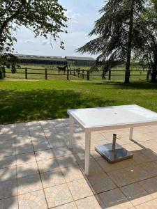 uma mesa de piquenique branca sentada num pátio com um campo em Rugles Cocooning em Rugles