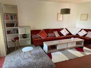 uma sala de estar com um sofá vermelho e uma mesa de centro em Rugles Cocooning em Rugles