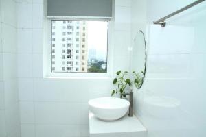 a white bathroom with a sink and a window at TTG Hostel DaLat in Da Lat