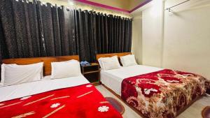 een slaapkamer met 2 bedden en een rode deken bij Hotel Shah Nibash Panthapath in Dhaka