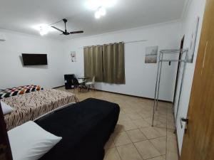 um quarto com uma cama e uma ventoinha de tecto em Pousada Indi em Ribeirão Preto