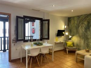 una sala da pranzo con tavolo e sedie bianchi di Apartamentos Inside Casa de la Alberca a Granada