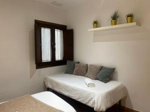 Habitación pequeña con cama y ventana en Apartamentos Inside Casa de la Alberca, en Granada