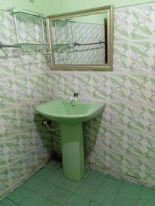 a bathroom with a green sink and a mirror at NMA Holiday INN 2 in Jaffna