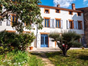 an exterior view of a white house with trees at La chambre du soleil in Lézat-sur-Lèze