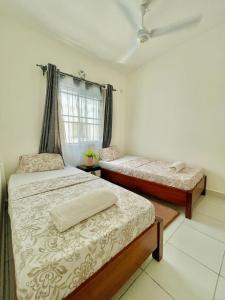 een slaapkamer met 2 bedden en een raam bij Ample home 2 bedroom apartment in Mombasa