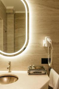 W łazience znajduje się umywalka z lustrem i telefon. w obiekcie Weekend Boutique Hotel w Kiszyniowie