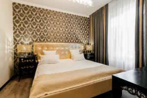 a bedroom with a large white bed and a wall at Weekend Boutique Hotel in Chişinău