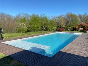 una piscina con terrazza in legno e acqua blu di Eden a Fumel