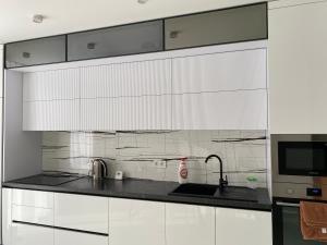 a white kitchen with white cabinets and a sink at Apartment 2 bedrooms in Chişinău