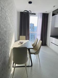 a dining room with a white table and chairs at Apartment 2 bedrooms in Chişinău