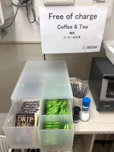 a box of change coffee and tea on a desk at 広島ゲストハウス Nice Day in Hiroshima