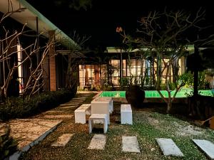 a backyard with a pool at night at Ren pool villa 清迈3卧泳池别墅 in Chiang Mai