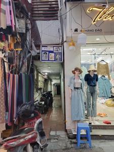 uma loja com dois manequins em frente a uma loja em H2_Homestay phố cổ _Check in tự động em Hanói