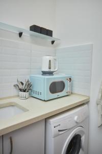a microwave sitting on a counter next to a washing machine at Ran's BIG Artistic Studio in Tel Aviv