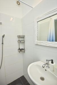 a white bathroom with a sink and a mirror at Ran's BIG Artistic Studio in Tel Aviv