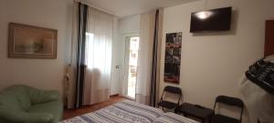 ヴェンティミリアにあるAppartamento Giusyのベッドルーム1室(ベッド1台、椅子、窓付)