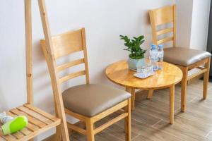 a table with two chairs and a table with water bottles on it at TTG Hostel DaLat in Da Lat