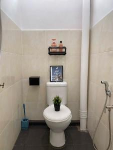 uma casa de banho com um WC com uma planta em City Center w/ Home Cinema @The 5000 studio em Kuala Terengganu