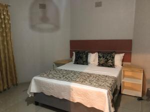 Un dormitorio con una cama grande con dos almohadas. en One Oban Place in Sunwich Port, en Port Shepstone