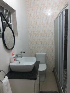 Un baño con lavabo, inodoro y espejo. en One Oban Place in Sunwich Port, en Port Shepstone