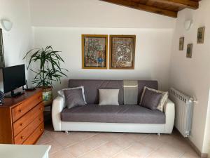 ein Wohnzimmer mit einem Sofa und einem TV in der Unterkunft Casa Marlù in Taormina