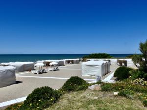 a resort with white tents and the ocean in the background at ili ili Hotel Boutique in Mar del Plata