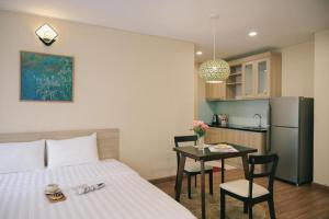 um quarto com uma cama, uma mesa e uma cozinha em LK Villa Hanoi West Lake em Hanói