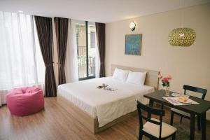 um quarto de hotel com uma cama e uma mesa com uma mesa em LK Villa Hanoi West Lake em Hanói