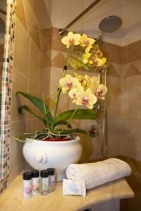 ein Badezimmer mit einer Vase mit Blumen darin in der Unterkunft Casa Marlù in Taormina
