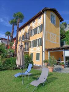 two chairs and an umbrella in front of a building at Casa Concerto in Brissago