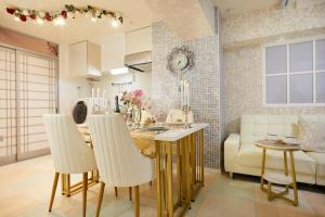 uma cozinha e sala de estar com mesa e cadeiras em Papillon Paradis Higashi-Shinjuku em Tóquio