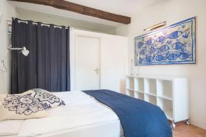 a bedroom with a bed with a blue and white blanket at Charming apartment w/courtyard in historical house in Lugano