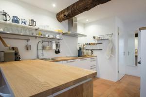 a kitchen with white cabinets and a wooden counter top at Charming apartment w/courtyard in historical house in Lugano