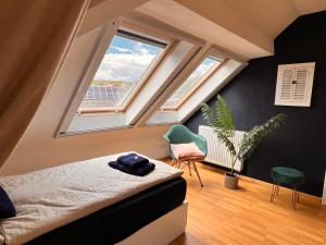 1 dormitorio con 1 cama y 2 ventanas en Ferienwohnung Aurora - Wlan, 2 Schlafzimmer, Küche und Bad, en Malterdingen