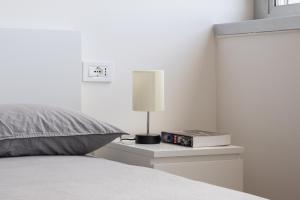 um quarto com uma cama com um candeeiro e um relógio em Paolo Fabbri Apartment em Bolonha