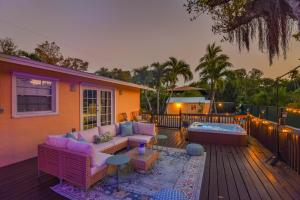 a patio with a couch and a tub on a deck at Paradise Palms - Movie Theater - Hot Tub - Pool - Arcade - Boat & RV Parking in Marathon
