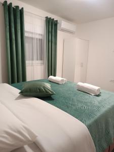 1 dormitorio con 1 cama grande y cortinas verdes en Apartment GORA, en Međugorje